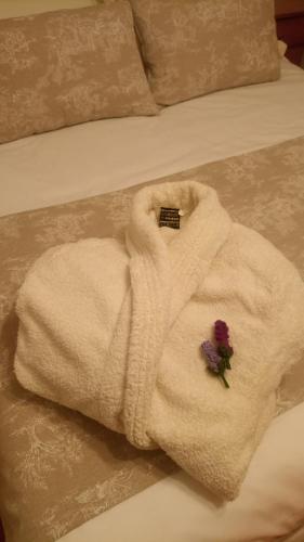 a white towel on a bed with a flower on it at Casa MI LUCÍA in Moratalla
