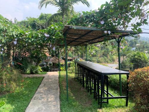 a pavilion with a roof in a garden at Palm garden Resort in Gisenyi