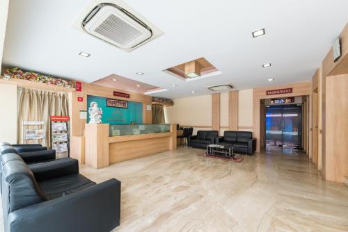 a lobby with a waiting room with chairs and a window at Treebo ESS Grande in Coimbatore
