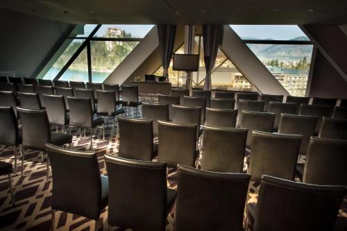 a room full of chairs in a building with windows at Hotel Kompas in Bled