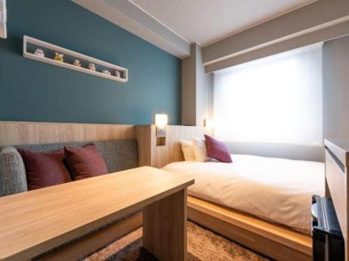 a bedroom with a large bed and a window at Hotel Naito Kofu Showa in Kofu