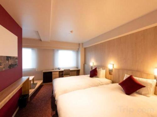 a hotel room with two beds and a television at Hotel Naito Kofu Showa in Kofu