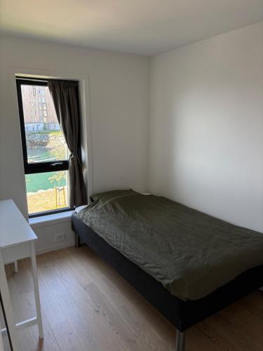 a bedroom with a bed and a window at New Aptartment Ocean View Central in Tromsø