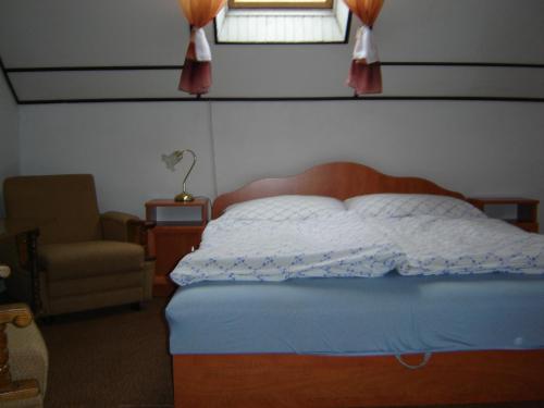 ザマールディにあるSomogyi Vendégházのベッドルーム1室(ベッド1台、椅子、窓付)