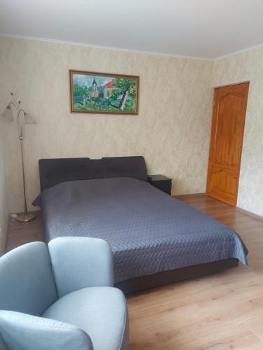 a bedroom with a bed and a chair and a couch at Dzīvoklis in Ventspils