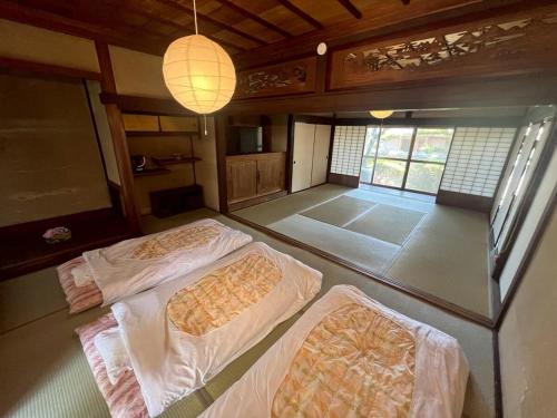 a room with two beds and two lamps in it at dannouraしげの里 1棟貸切 築120年古民家 バーベキュー 海が見える in Takamatsu
