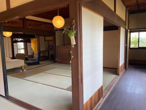 a living room with a large glass door to a room at dannouraしげの里 1棟貸切 築120年古民家 バーベキュー 海が見える in Takamatsu