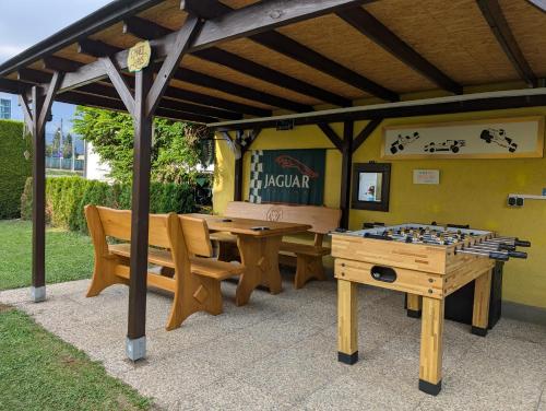 a gazebo with a ping pong table and benches at Harti Haus in Zeltweg
