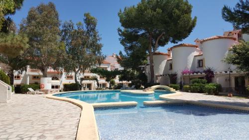 a swimming pool in front of a building at MR Hotelet de la Raconà & Apartments in Denia