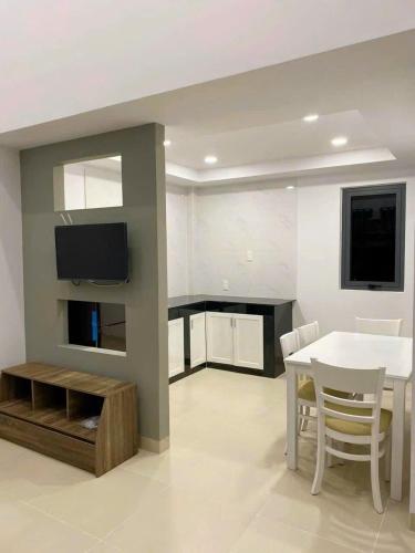 un soggiorno con un tavolo e una TV a parete di MIA's homestay a Phu Quoc