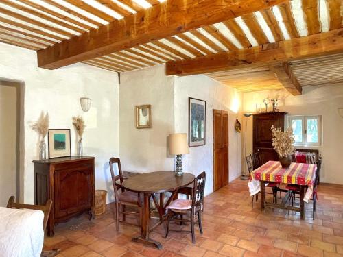 a room with a table and chairs and a bed at Maison paisible au coeur du Luberon in Bonnieux