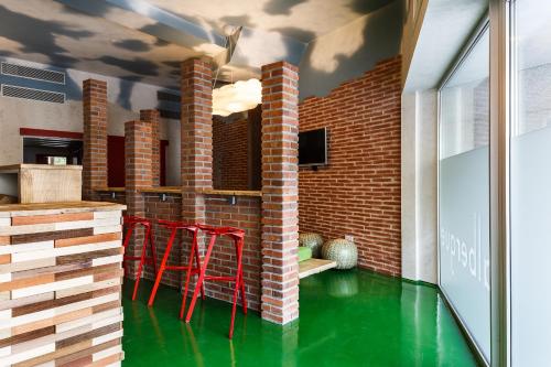 a kitchen with a green floor and red stools at Blanco Albergue in Santiago de Compostela