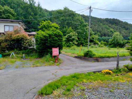 an empty road in front of a house with trees at Ondolphin in Narusawa