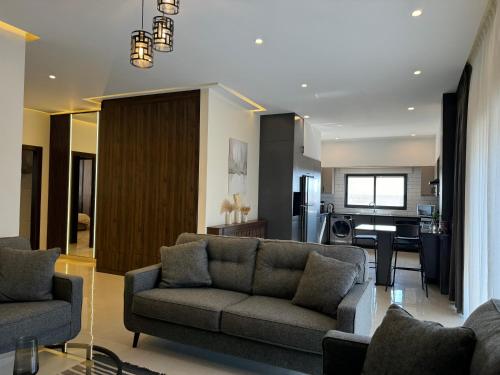 a living room with a couch and a kitchen at The view in Māḩiş
