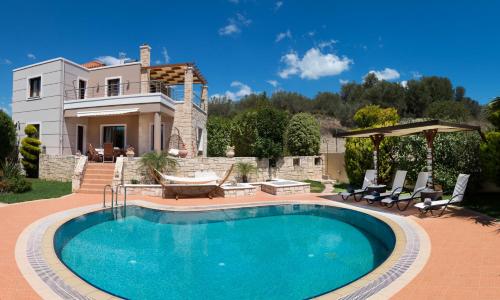 a swimming pool in front of a house at Villa Gianna in Almyrida