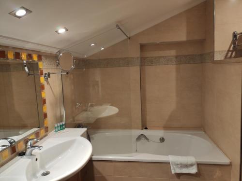 a bathroom with a bath tub and a sink at Hotel Palacio de la Magdalena in Soto del Barco