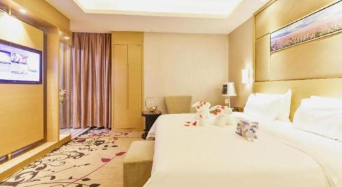 a hotel room with a bed with two stuffed animals on it at Shenzhen Lavande Hotel Airport Terminal Branch in Shenzhen