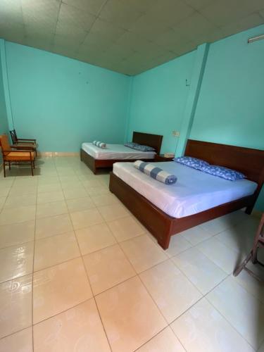 two beds in a room with blue walls at Lang Chai Guesthouse in Mui Ne
