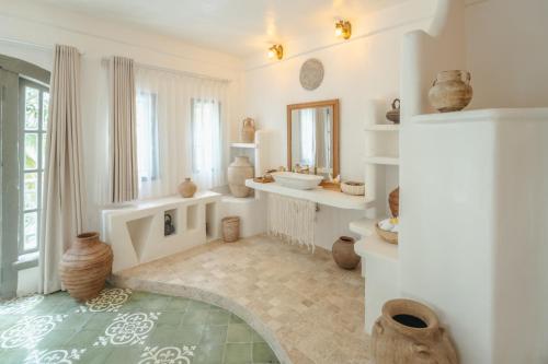 a white room with a sink and vases on the floor at La Santa Rosa in Uluwatu
