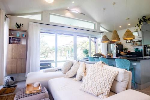 Una sala de estar con un sofá blanco y una ventana grande. en Villa Del Mar - Blue Venao 3BR, en Playa Venao