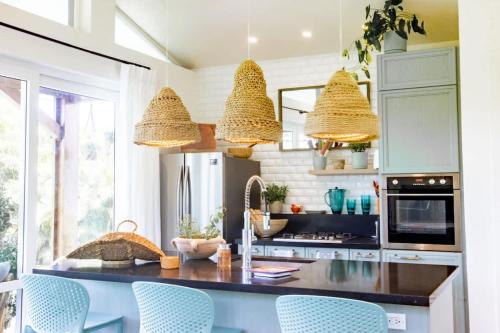 cocina con encimera con sillas azules en Villa Del Mar - Blue Venao 3BR, en Playa Venao
