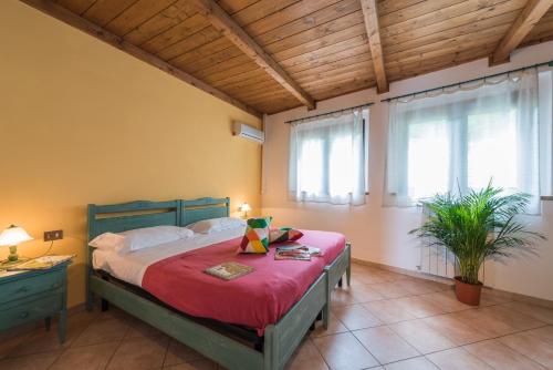 a bedroom with a bed with red sheets and windows at Camping Village Il Poggetto in Troghi