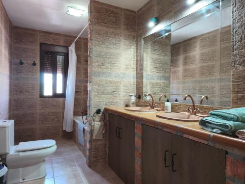 Un baño con dos lavabos y un inodoro. en Casa Montaña, en Arriate