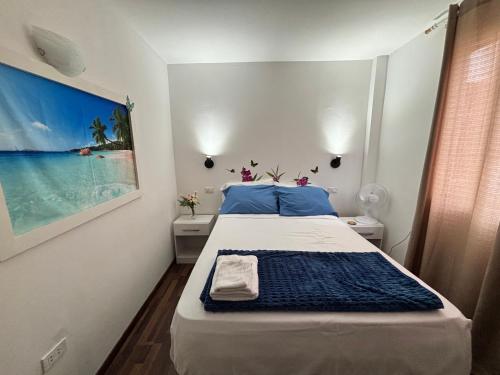 Un dormitorio con una cama grande con almohadas azules. en Mini Apartamento con Aire acondicionado, en Tumbes