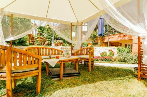 a patio with a table and chairs under a tent at Cunda Esen Hotel in Ayvalık