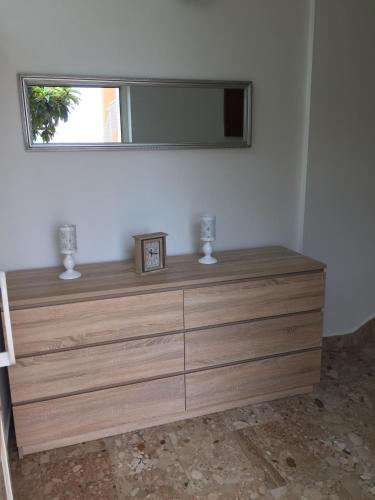 a wooden dresser with a mirror on top of it at Apartments Rube in Primošten