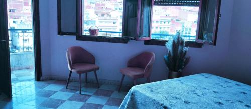 a room with two chairs and a table and windows at lovely place in Souani