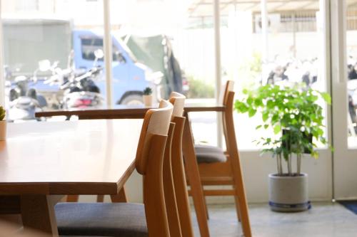 a dining room with a table and chairs and a plant at 有某行旅 yóu mǒu hostel in Tainan