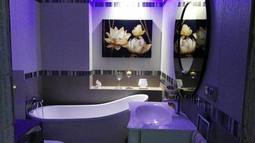 ウストカにあるApartamenty De Soleilの紫色のバスルーム(バスタブ、シンク付)