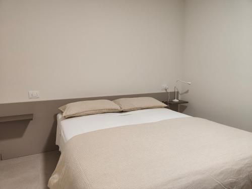 a bedroom with a white bed with two pillows at Soggiorno in villa - apt with kitchen and terrace in Gambellara