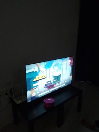 a flat screen tv sitting on a table in a dark room at Homestay Permaipura in Gua Sai