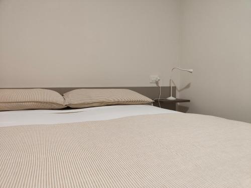a bedroom with a white bed and a lamp at Soggiorno in villa - apt with kitchen and terrace in Gambellara