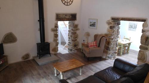 a living room with a couch and a wood stove at The Barn at Cae Bach in Gwalchmai