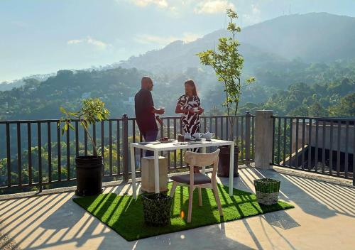 a man and a woman standing on a balcony with a table at Kandy City Panorama in Kandy