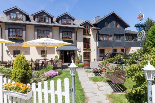 a white fence in front of a building at Augustusberg Hotel & Restaurant in Bad Gottleuba