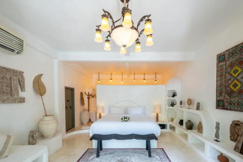 a bedroom with a bed and a chandelier at La Santa Rosa in Uluwatu