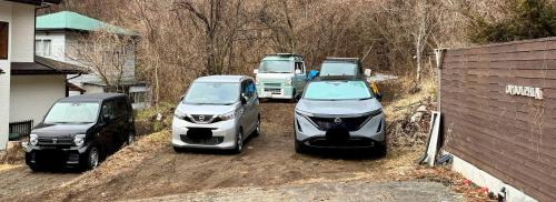 a group of three cars parked in a driveway at Ondolphin in Narusawa