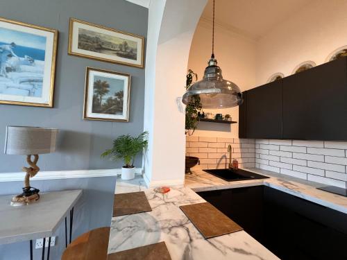 eine Küche mit Spüle und Hängeleuchte in der Unterkunft Sea Spray Victorian Apartment in St. Leonards