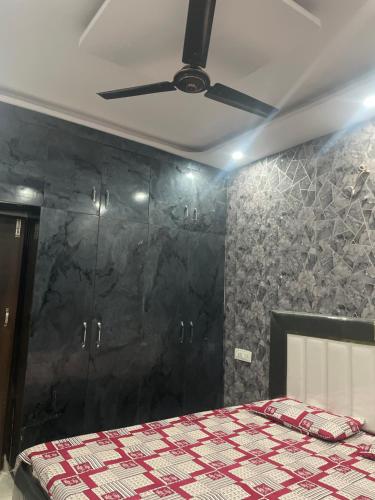 a bedroom with a bed and a ceiling fan at Parveen Guest House in Mohali