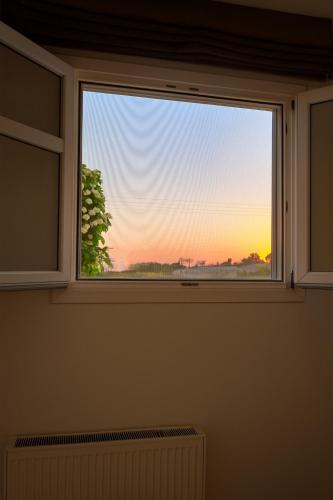 a window with a view of the sunset at YouGa Nest in Vívlos