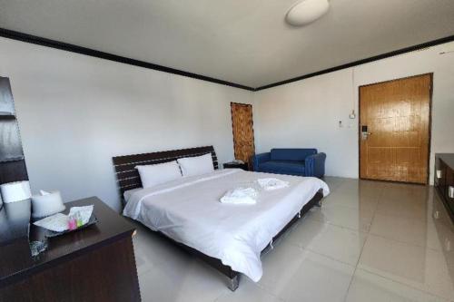 a bedroom with a large bed and a blue chair at ONE Residence in Pathum Thani