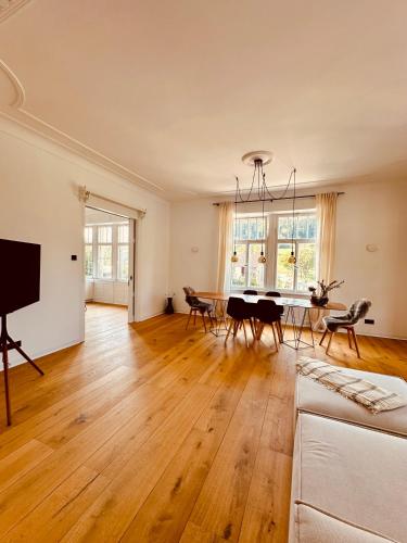 an empty living room with a table and chairs at luxuriöse Altbau Wohnung in Denkmal-Villa in Aidlingen