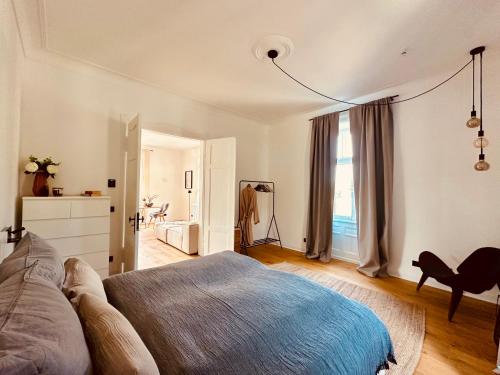 a bedroom with a bed and a chair and a window at luxuriöse Altbau Wohnung in Denkmal-Villa in Aidlingen