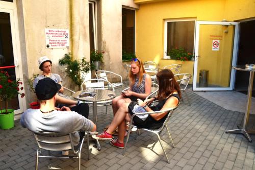 a group of people sitting in chairs on a patio at Do Step Inn Home - Hotel & Hostel in Vienna