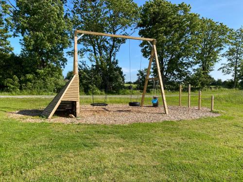 a wooden swing set in a park at Hansingastugan Bed and Kitchen Guesthouse in Varberg