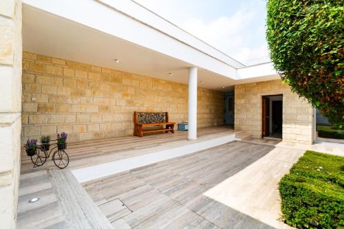 a patio with a bench and a brick wall at Goudi Residence in Goudhi